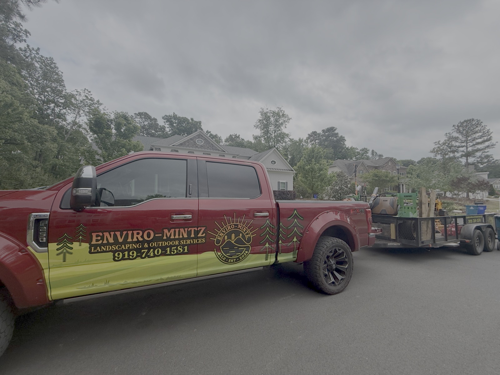 The branded Enviro-Mintz Landscaping truck and equipment trailer